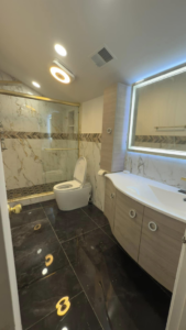 A beautifully renovated bathroom featuring a new shower, smart toilet, modern vanity, and lighted mirror by Liberty Tech Home Improvement in Edison, NJ.