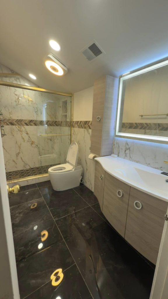 A beautifully renovated bathroom featuring a new shower, smart toilet, modern vanity, and lighted mirror by Liberty Tech Home Improvement in Edison, NJ.