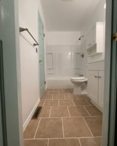 A newly renovated bathroom with a tile floor and modern fixtures by Creative Touch Renovations LLC in Harrisburg, PA.