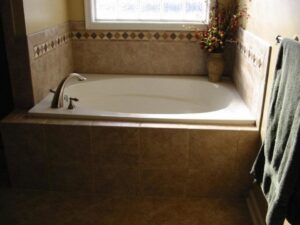 A renovated bathroom showcasing a tiled bathtub and surrounding area, completed by WHE Construction in Virginia Beach, VA
