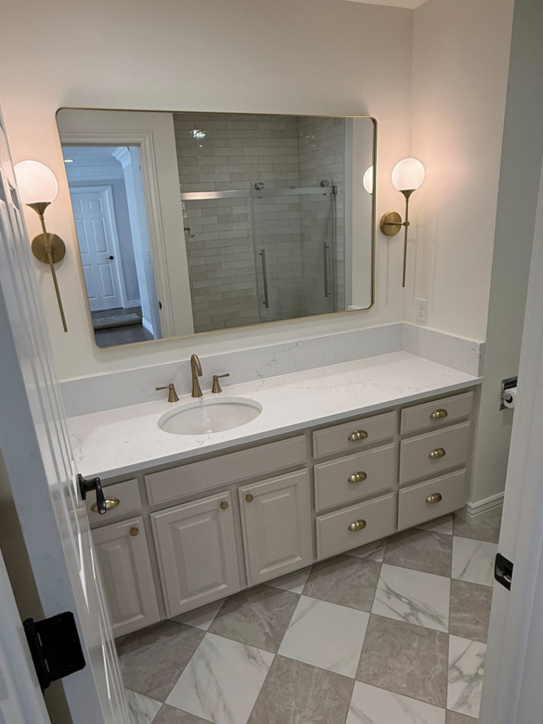 A fully renovated bathroom featuring a new vanity, mirror, and checkered tile floor by Patriot Tile LLC in Skiatook, OK.