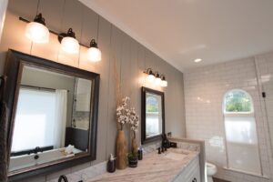 A newly renovated bathroom with dual vanities, mirrors, and modern lighting by Harpeth Painting, LLC. in Nashville, TN.