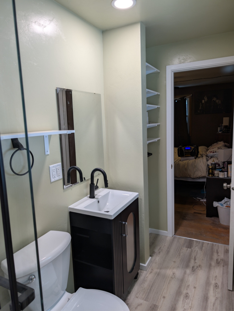 A newly renovated bathroom featuring a modern vanity, sink, and mirror by A&A Property Renovations LLC in Green Bay, WI.