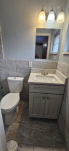 A newly renovated bathroom featuring a modern vanity and toilet by Williams Custom Construction in Orlando, FL.