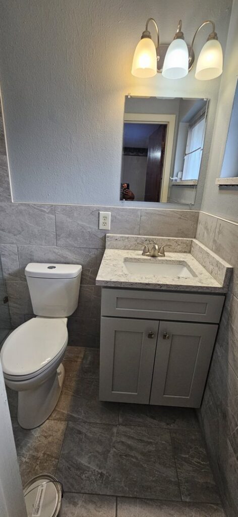 A newly renovated bathroom featuring a modern vanity and toilet by Williams Custom Construction in Orlando, FL.