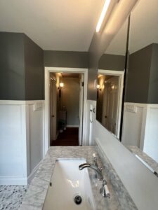 A renovated bathroom featuring a new vanity, mirror, and wainscoting by Lynden Remodeling in Cincinnati, OH.