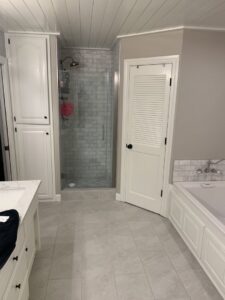 A renovated bathroom featuring a walk-in shower, vanity, and bathtub by Holaway Custom Builds in Fayetteville, AR.