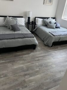 A beautifully renovated bedroom with two beds, showcasing work by Coastal Pointe Homes in Tampa, FL.