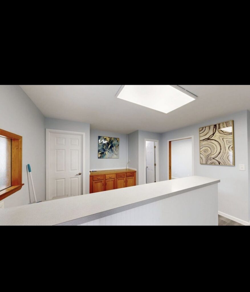 Interior view of a renovated commercial space with new paint, flooring, and custom cabinetry by EJ Drywall Plus in Kearney, NE.