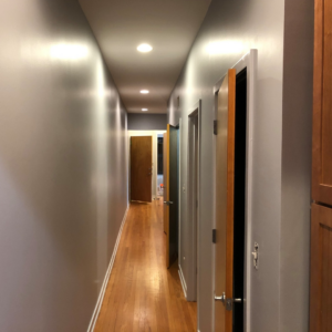 A newly renovated hallway with fresh paint and modern recessed lighting by Pro Home Solutions in Aiken, SC.