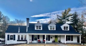 A beautifully renovated house exterior with a new roof and updated porch by DSD Construction in Saint Louis, MO.