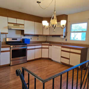 A beautifully renovated kitchen with stainless steel appliances, white cabinets, and wood flooring, completed by 1st State's Finest LLC in Middletown, DE.