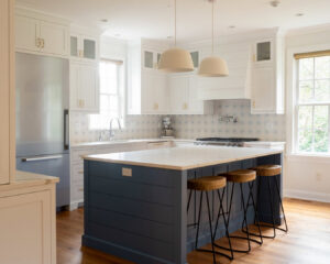 A beautifully renovated kitchen featuring a blue island and white cabinets, completed by Home Made Easy in Norwalk, CT.