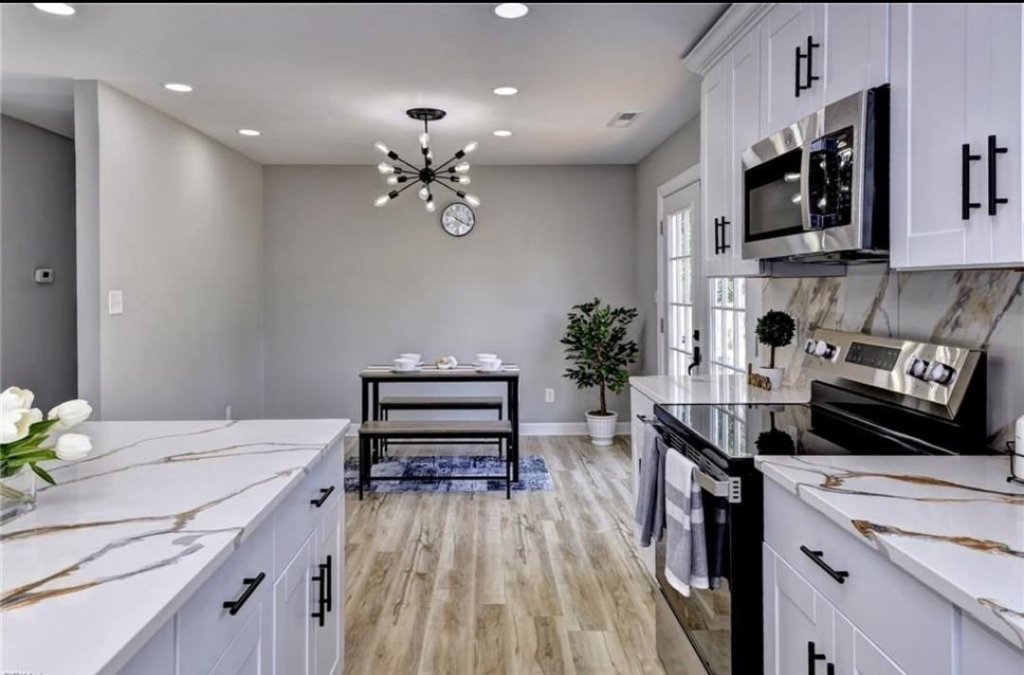 A beautifully renovated kitchen and dining area with new flooring and modern lighting by YH torres.home improvement.LLC in Newport News, VA