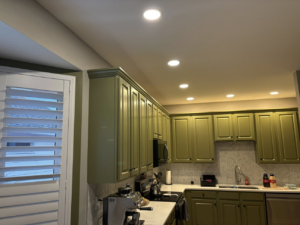 A beautifully renovated kitchen featuring new green cabinets and a white honeycomb backsplash by Mauricio's Home Improvements in Raleigh, NC.
