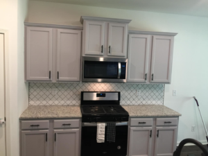 A newly renovated kitchen featuring light gray cabinets and a stylish backsplash installed by Gardner Home Services in Pleasant Grove, AL.