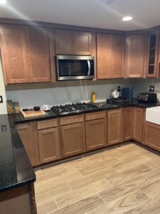 A renovated kitchen featuring warm wood cabinets and black granite countertops by 3Rivers General Contracting in Pittsburgh, PA.
