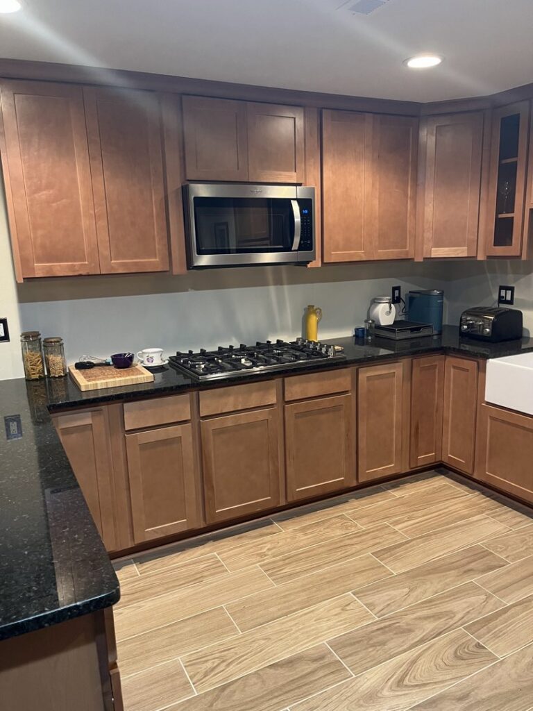 A renovated kitchen featuring warm wood cabinets and black granite countertops by 3Rivers General Contracting in Pittsburgh, PA.