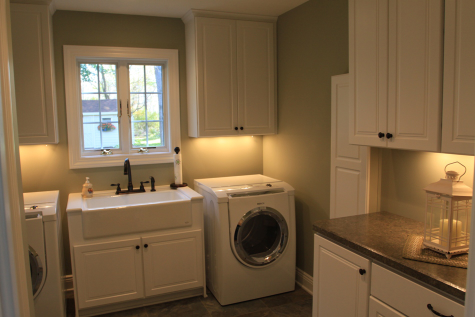A beautifully renovated laundry room with white cabinets and a large sink by Kline Custom Homes and Remodelers in Canton, OH.
