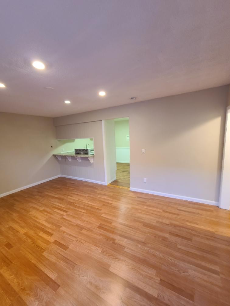 A beautifully renovated living room with new hardwood floors and recessed lighting by Premier Home Services in Fullerton, CA