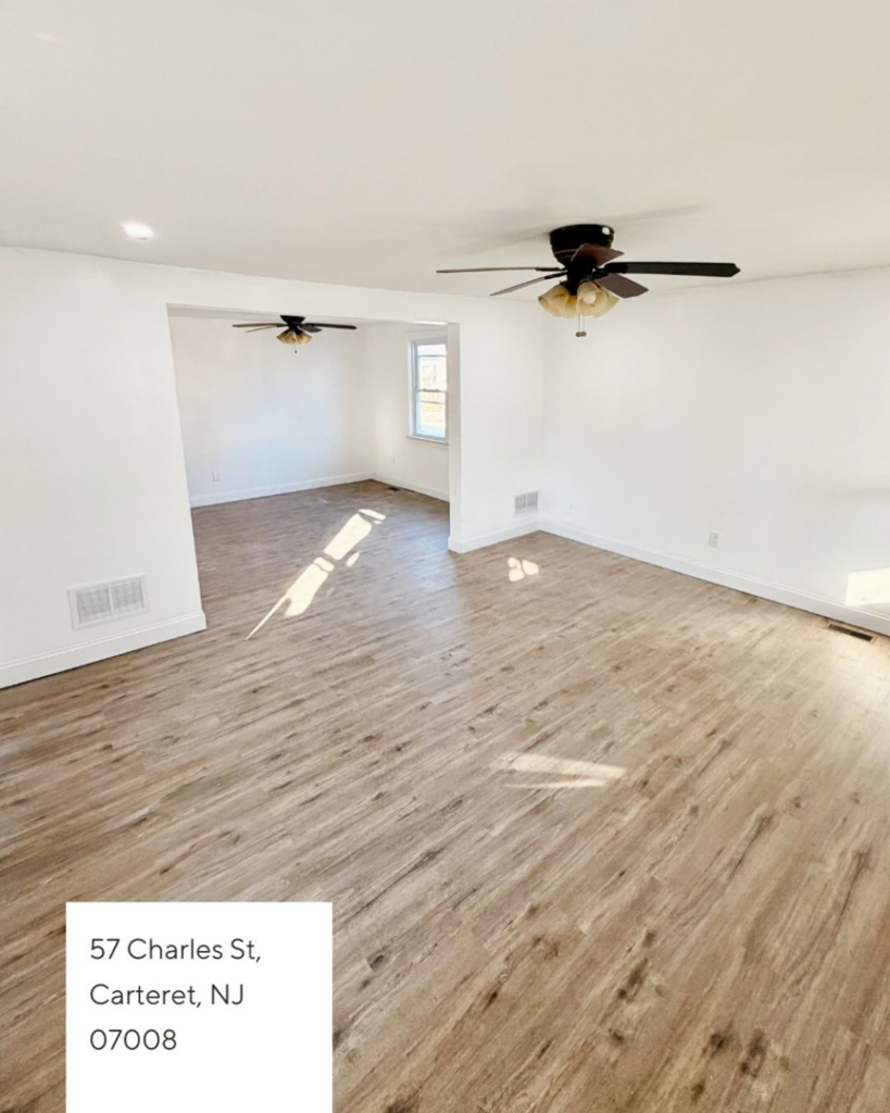 A renovated living room with new wood-look flooring and ceiling fans, completed by I Revive Homes in Edison, NJ.