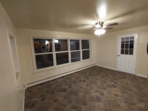 Renovated living room with new windows, door, and tile-look flooring by Jones Construction & Lawn Services, Newport, PA