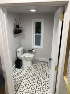 A newly renovated powder room bathroom featuring patterned floor tiles and a modern toilet by Elde Contracting in Saint Paul, MN.
