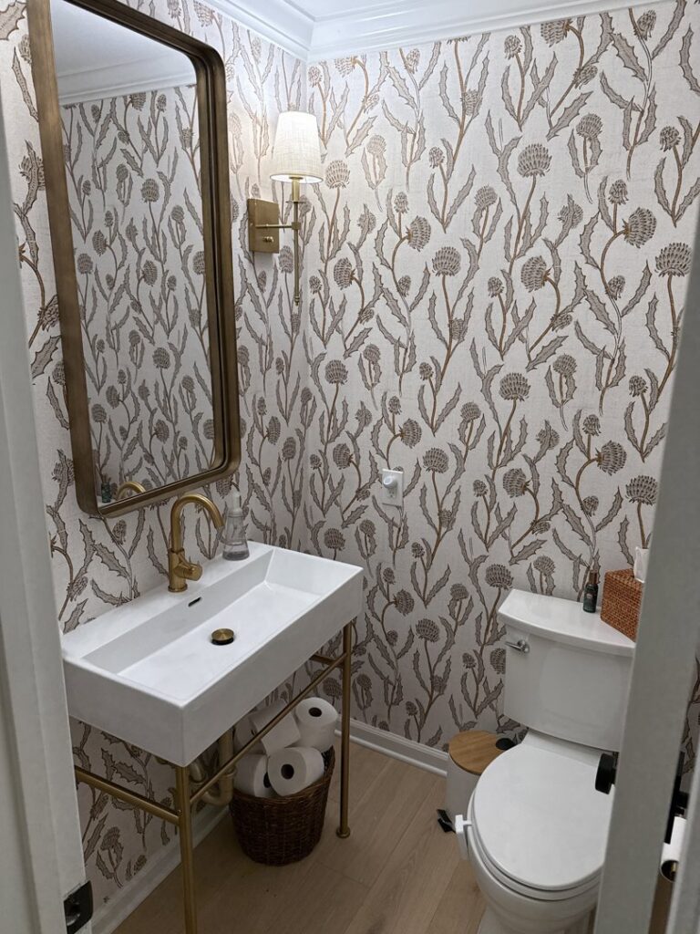 Renovated powder room with a modern vanity, toilet, and patterned wallpaper by HomePro Improvements, Roswell, GA.