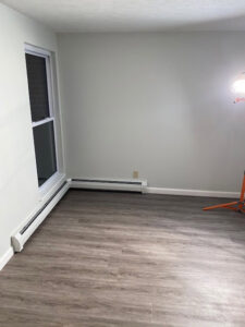 A newly renovated room featuring new flooring and freshly painted walls, completed by Sini's Handyman Services in Falmouth, ME.