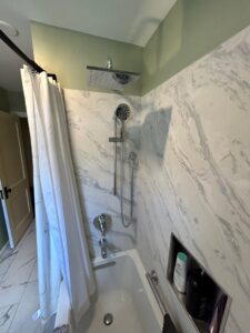 A beautifully renovated shower and tub combination with marble-look wall panels by Ready & Able in Etters, PA.