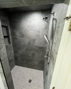 A renovated shower featuring new tile and a built-in niche by Okie Custom Designs in Stillwater, OK.