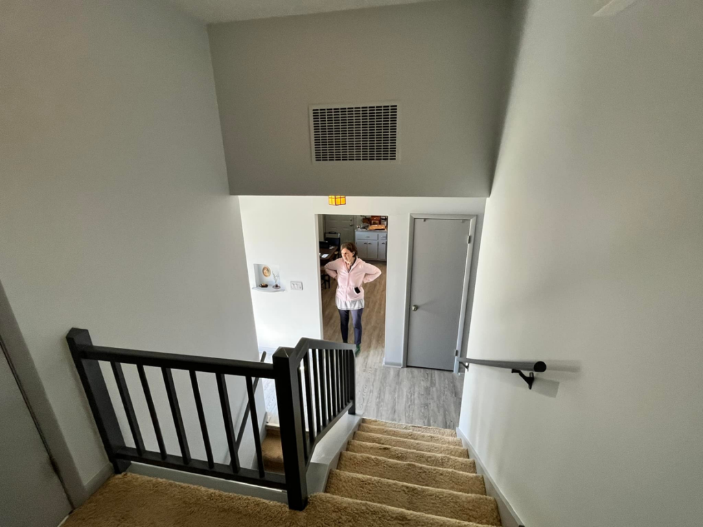 A renovated staircase featuring new black railings and freshly painted walls by Lambert's Residential Painting And More LLC in Fort Wayne, IN.