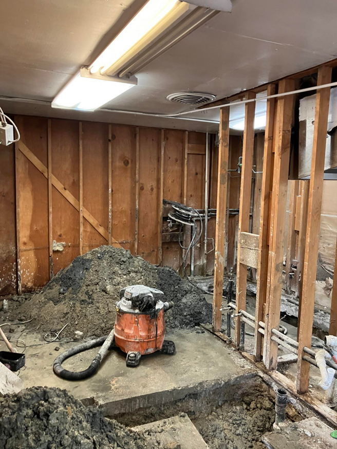 Renovation work showing exposed walls, floor trenches, and a shop vac by JB Renovations in Houston, TX.
