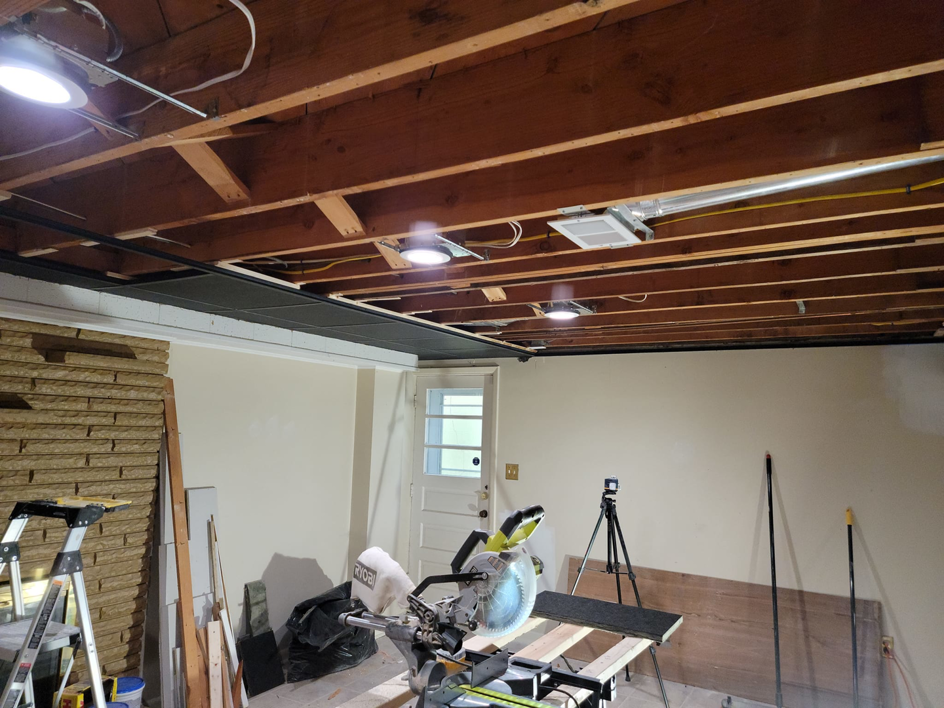 Renovation work in progress with a miter saw and exposed ceiling joists by Jake Fortin Carpentry Services in Pittsburgh, PA.