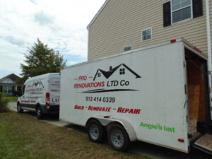 Pro Renovations Savannah, GA work vehicles and trailer with materials at a job site.
