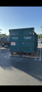 A Quality Bin Inc. dumpster with 'Rent a Dumpster' visible, placed in a parking lot in Los Angeles, CA.