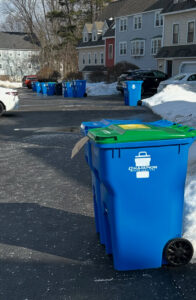 A blue residential trash and recycling bin from Champion Waste Services in the snow in Londonderry, NH.