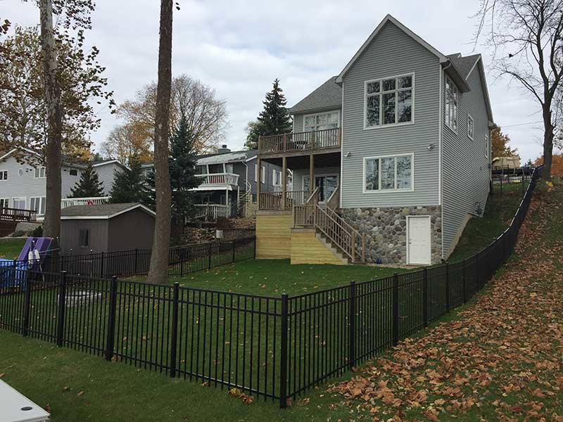 A residential backyard enclosed by a black metal fence installed by R & C Fence in Fort Wayne, IN.
