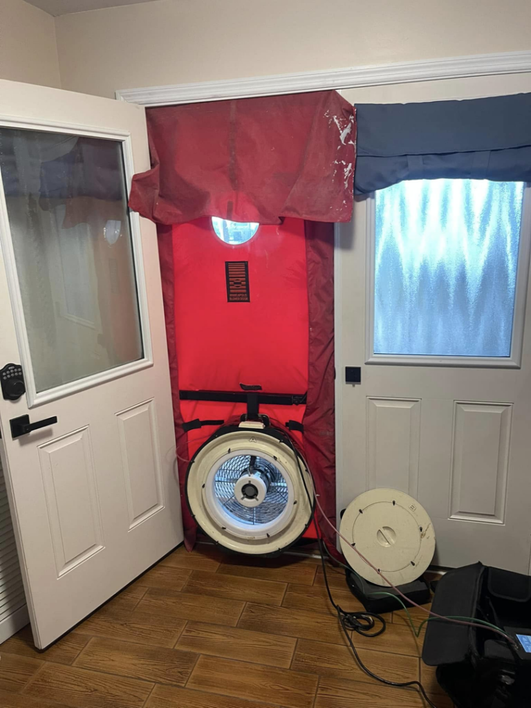 A blower door test setup in a residential doorway for energy efficiency testing by Green Energy Testing in Tampa, FL.