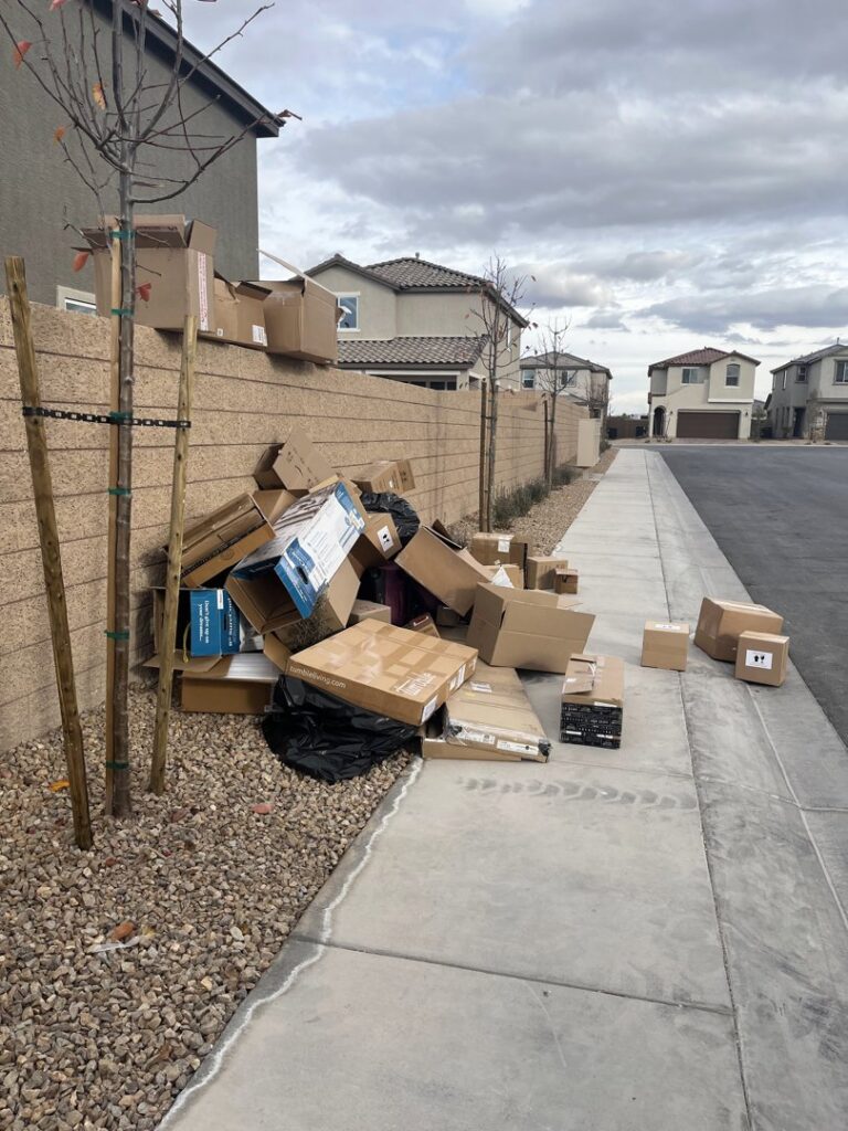 A large pile of cardboard boxes and debris on a residential sidewalk, ready for junk removal by Gone Junkin' Vegas in Henderson, NV.