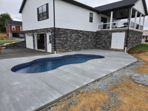 An expansive concrete pool deck and patio area completed for a home by J&M Concrete Construction, LLC in Fayetteville, PA.