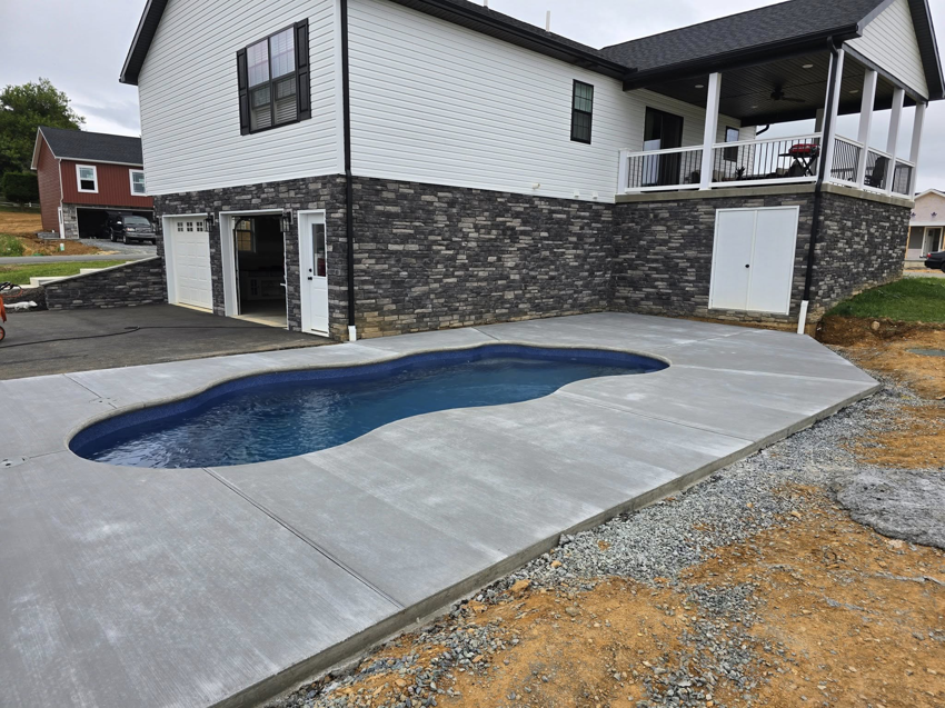 An expansive concrete pool deck and patio area completed for a home by J&M Concrete Construction, LLC in Fayetteville, PA.