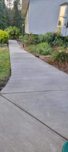 A long, newly installed concrete sidewalk alongside a house, provided by Zambrano Concrete in Duluth, MN.