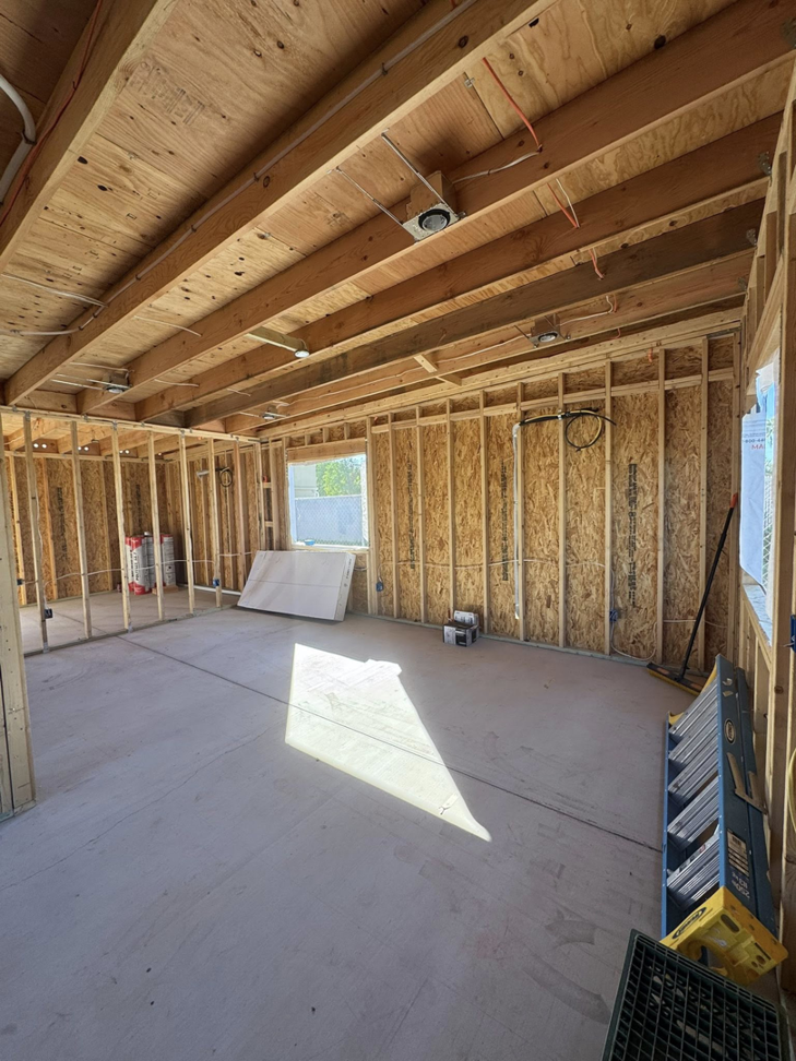 Interior view of residential construction showing wooden wall framing and ceiling joists by CK Customs LLC in Surprise, AZ.