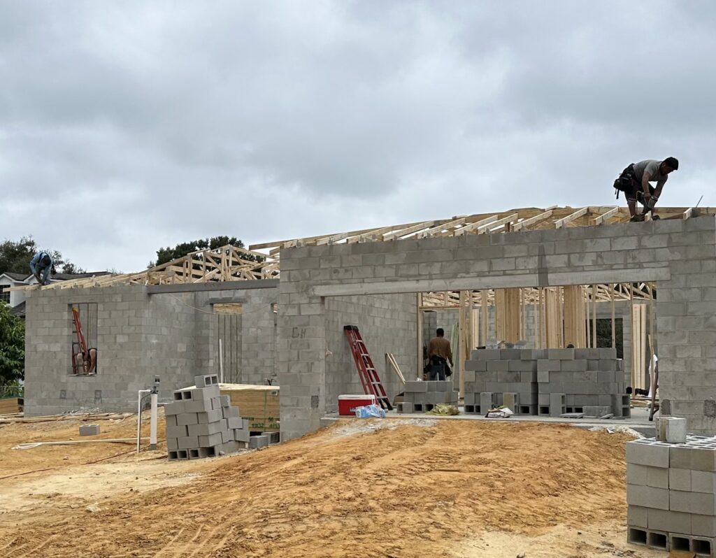 Workers installing roof trusses on a residential construction project by Beyond Builders in Tampa, FL