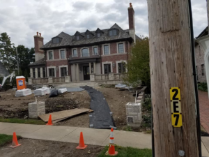 A large residential construction site with materials and disturbed ground, managed by National Kurb Kut in Naperville, IL.
