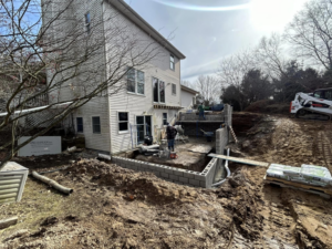 Residential construction site with foundation work and equipment by Steve Way Builders, LLC in Lansing, MI