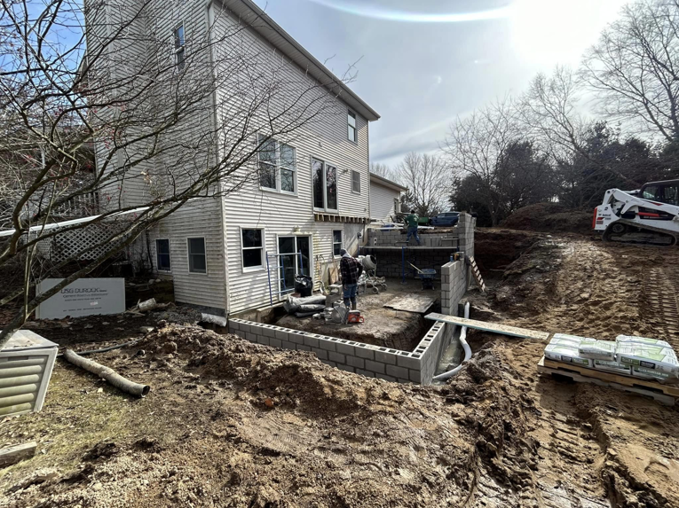 Residential construction site with foundation work and equipment by Steve Way Builders, LLC in Lansing, MI