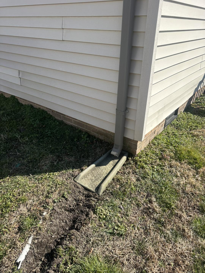 A residential drainage system with a downspout and channel installed by Jps handyman services,inc in Hampton, VA.