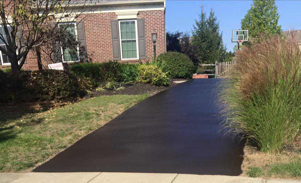 A newly sealcoated residential asphalt driveway, showcasing quality work by Cincy SealCoating in Morrow, OH.